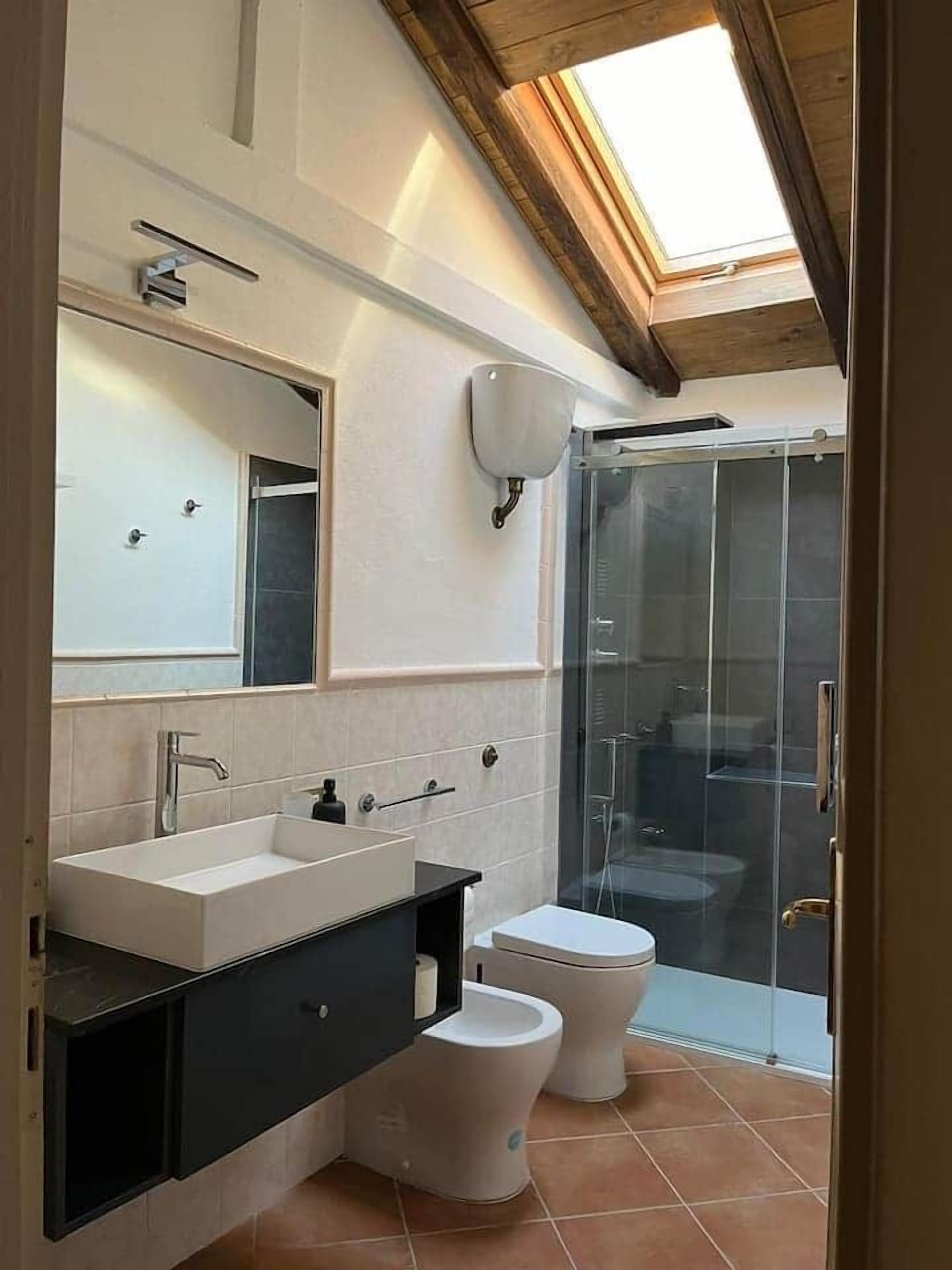 Regadera, secadora de cabello, bidet, papel de baño 