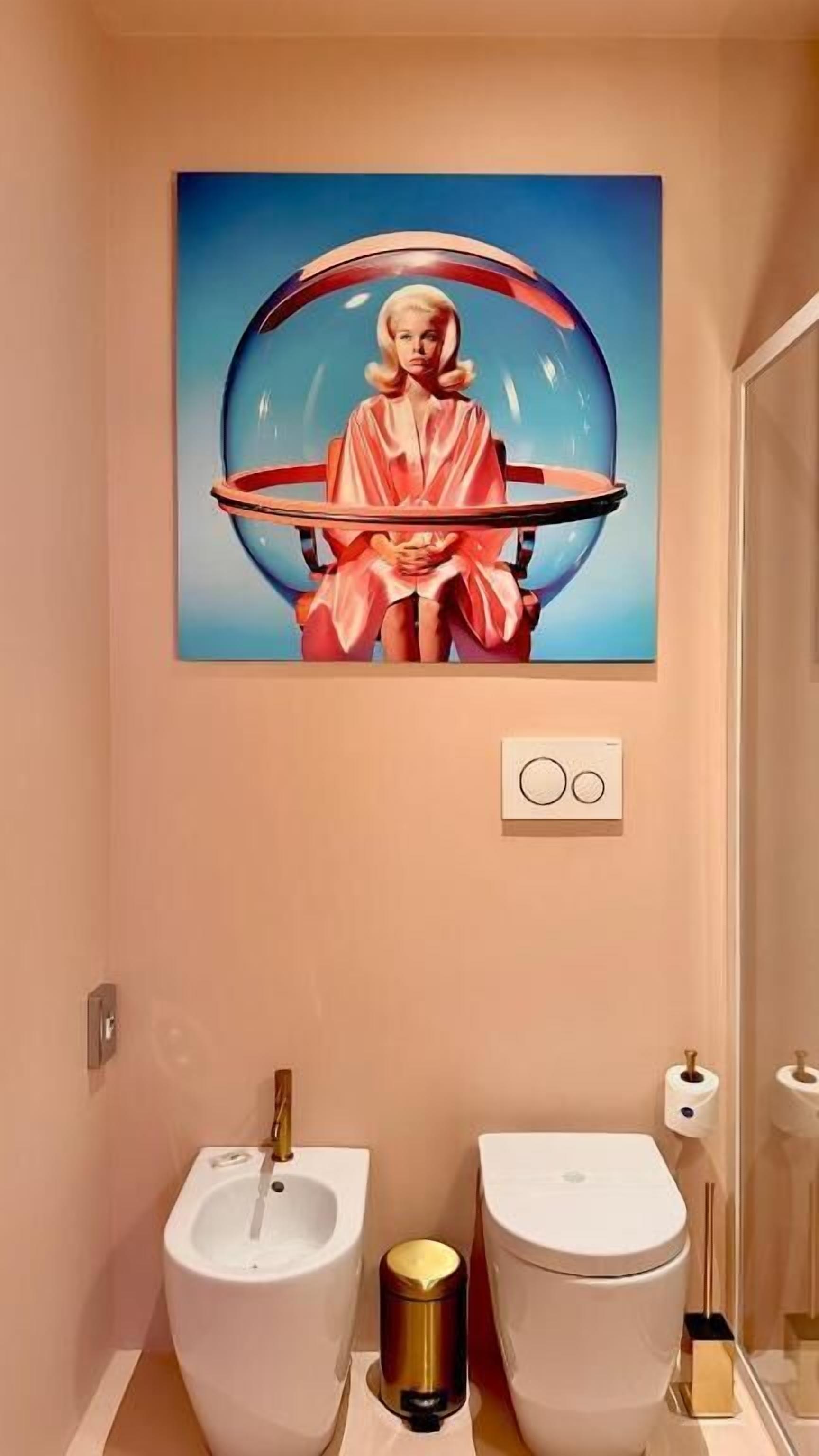 Ein Badezimmer mit einem großen Gemälde einer Frau in einer Badewanne, zwei Toiletten und einem Bidet.