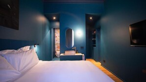 A modern hotel room with a large bed, a bedside table, a mirror, and a small bathroom with a sink and toilet. - Fontana 16 Rooms (Milan)