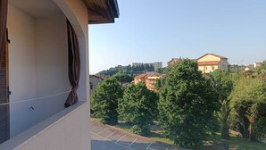 A balcony with a view of a parking lot and surrounding buildings. - Stella Marina: Three-Bedroom Apartment with Pool, 3 Balconies, and Free Parking (Pietra Ligure)