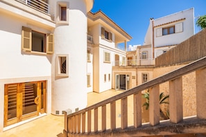 Un immeuble à plusieurs étages doté de balcons, d’un escalier et d’une cour intérieure.