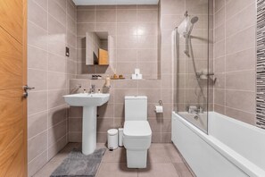 A bathroom with a sink, toilet, and shower. - Modern 2‑Bed Apt | Contractor Friendly | Parking (Birmingham)