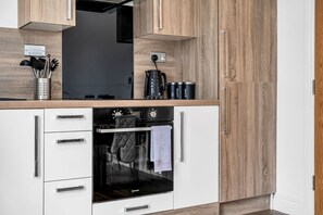 Eine Küche mit Einbauofen, Kaffeemaschine und Wasserkocher.