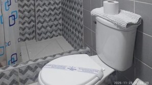 A bathroom with a shower, toilet, and a towel rack. - HOTEL SAN ANTONIO  (Puno)