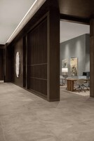 Un interior moderno con suelo de madera, un amplio ventanal corredero y una zona de estar con mesa y sillas.