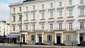 Un immeuble à étages doté d’un style architectural classique, avec une entrée imposante sur laquelle est apposée une enseigne indiquant « FOUR POINTS FLEX ».