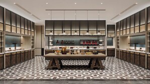 Une cuisine moderne dotée d’un îlot central, de luminaires suspendus et d’un revêtement de sol à motifs.