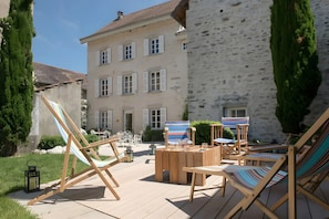A courtyard with outdoor seating, a hammock, and a building with multiple windows.