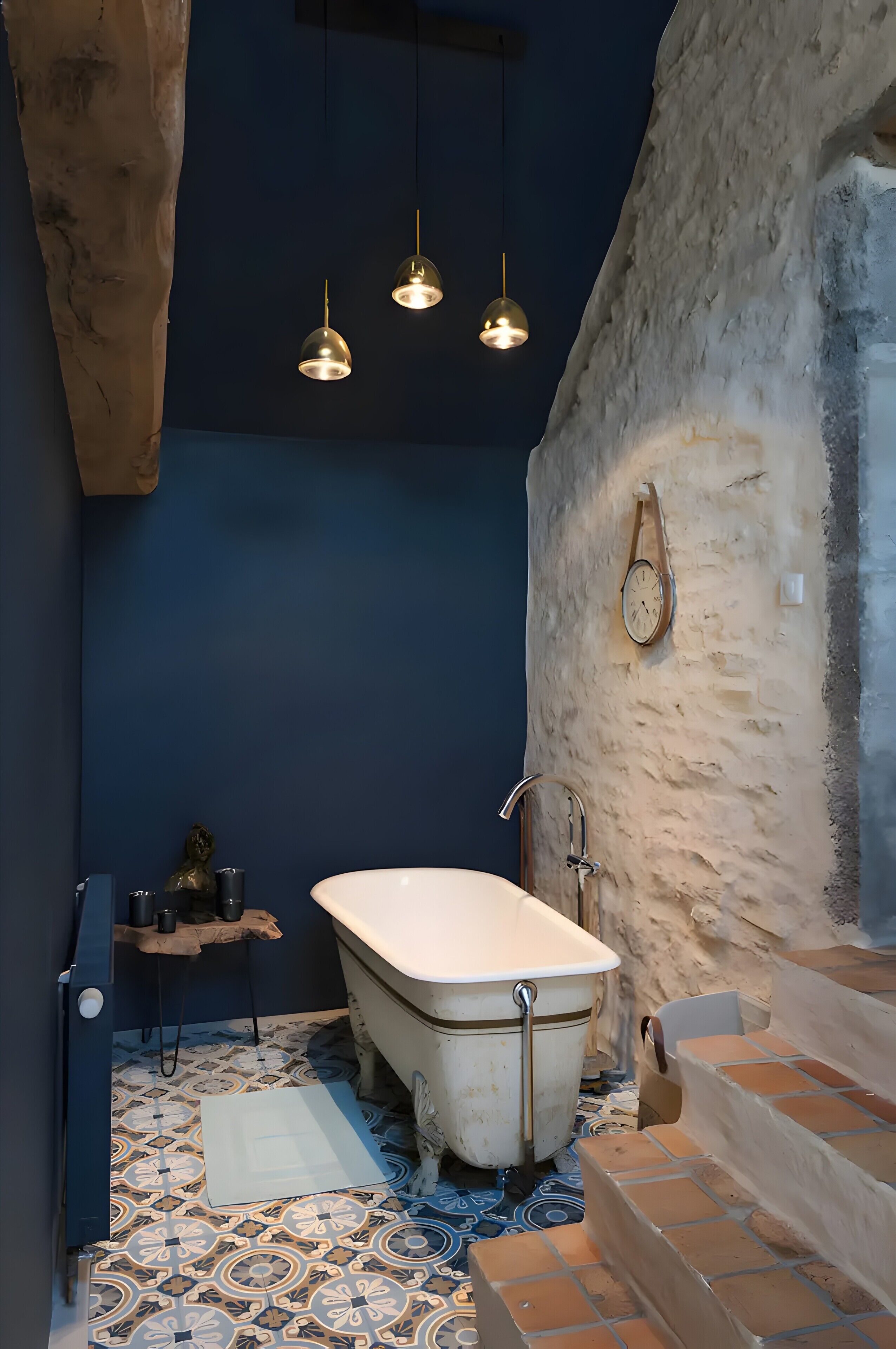 A bathroom with a bathtub, a wooden shelf, and a clock on the wall.