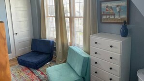 A room with a bed, a dresser, a window with curtains, and a painting on the wall. - 3-bedroom house in charming Ocean City with AC for relaxing stays (Ocean City)