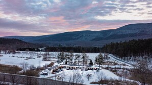 A snow-covered landscape with a building that has multiple parking spaces and a driveway leading to it. - 11, Peaceful retreat in Vermont (Manchester)