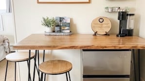 A kitchen area with a wooden countertop, two stools, a refrigerator, and a framed picture on the wall. - 3, cozy pet friendly Vermont retreat - two doubles (Manchester)