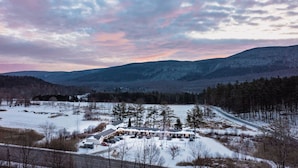 A snow-covered landscape with a building that has multiple parking spaces and a driveway leading to the entrance. - 3, cozy pet friendly Vermont retreat - two doubles (Manchester)