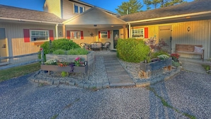 A two-story house with a covered patio, outdoor seating, and a well-maintained garden. - 3, cozy pet friendly Vermont retreat - two doubles (Manchester)