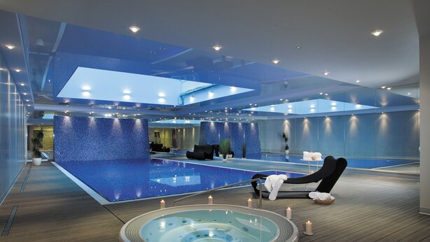 A modern spa with a large pool, a hot tub, and a seating area with a view of the pool. - Szafarnia 2 by Grand Apartments (Gdańsk)