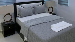 Een moderne slaapkamer met een bed, bedlampjes en een plafondlamp.