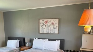 A bedroom with two beds, a wooden table, and a chair. - Room 2, double room - sleeps 4 (Manchester)