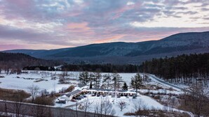 A snow-covered landscape with a building that appears to be a lodge or inn, featuring a parking area and a road leading to it. - Room 2, double room - sleeps 4 (Manchester)