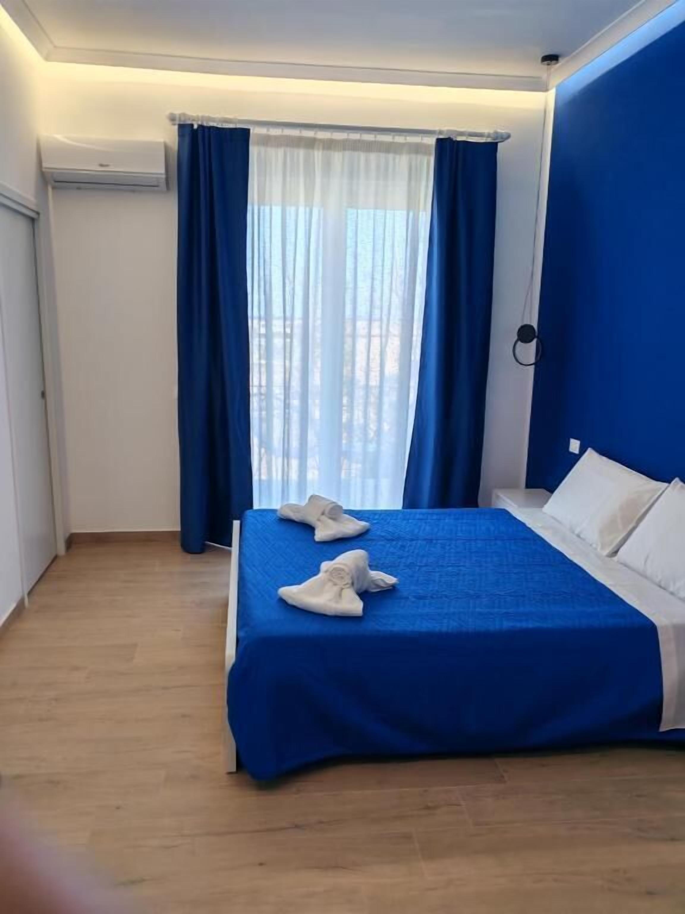 Une chambre d’hôtel avec un lit, des rideaux bleus et une vue par la fenêtre.