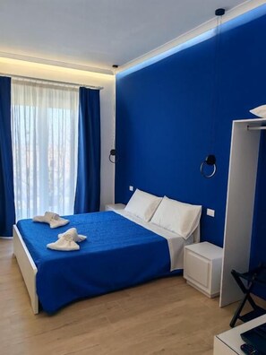 Ein modernes Hotelzimmer mit einem großen Bett, einem Schreibtisch und einem Kleiderschrank.