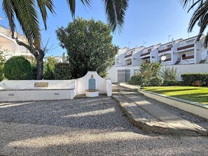 A courtyard with a tiled monument, gravel paths, and a well-maintained lawn. - JARDINS I BX 27 Roses / Roses - INTERimmo (Rosas / Roses)