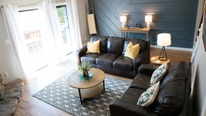 A living room with a sofa, coffee table, and lamps.