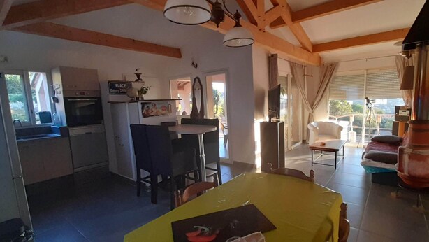 A spacious living area with a dining table, kitchen, and a balcony with a view. - House Swap Porticcio Sea View (Grosseto-Prugna)