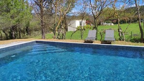 A rectangular swimming pool with clear blue water, surrounded by trees and a grassy area. - Houses with swimming pool - View of Peyrepertuse castle (Pays Cathare) (Rouffiac-des-Corbières)