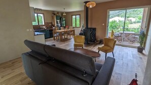 A spacious living area with a sofa, a dining table, and chairs. There is a kitchen in the background with a stove and a dining area. - Houses with swimming pool - View of Peyrepertuse castle (Pays Cathare) (Rouffiac-des-Corbières)