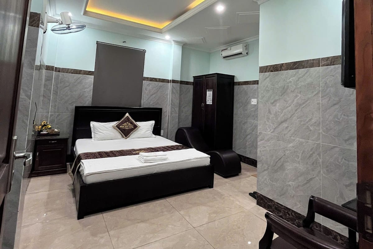 Ein modernes Hotelzimmer mit einem Bett, einem Schreibtisch und einem Sessel.
