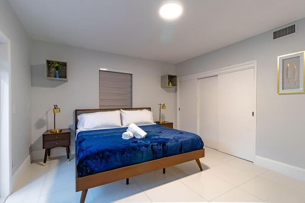 A bedroom with a bed, bedside tables, a wardrobe, and a ceiling light.