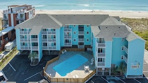 A beachfront hotel with multiple buildings, a swimming pool, and a beach view. - Modern Beachfront Condo w/pool Carolina Beach (Carolina Beach)