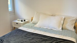 A bedroom with a bed, a bedside table, and a window. - Single room for rent for single days or weekends. (Sevilla este)
