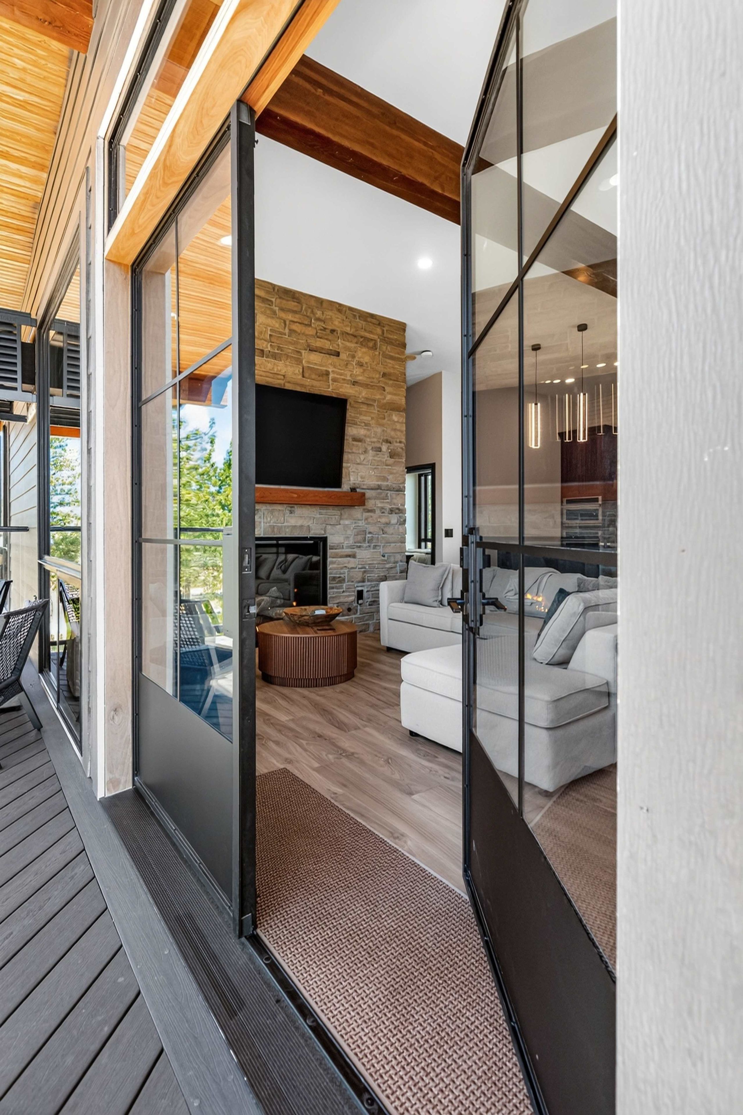 A modern interior with a stone fireplace, a flat-screen TV, and a cozy seating area.