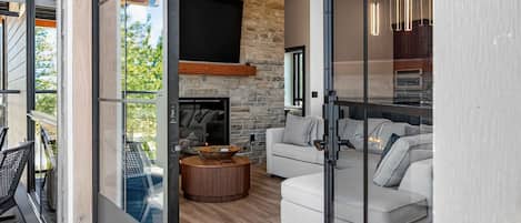 A modern interior with a stone fireplace, a flat-screen TV, and a cozy seating area.