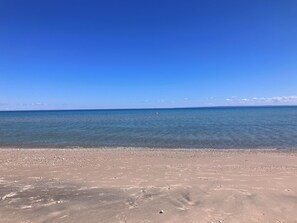 Een strand met helderblauw water en een zandstrand.