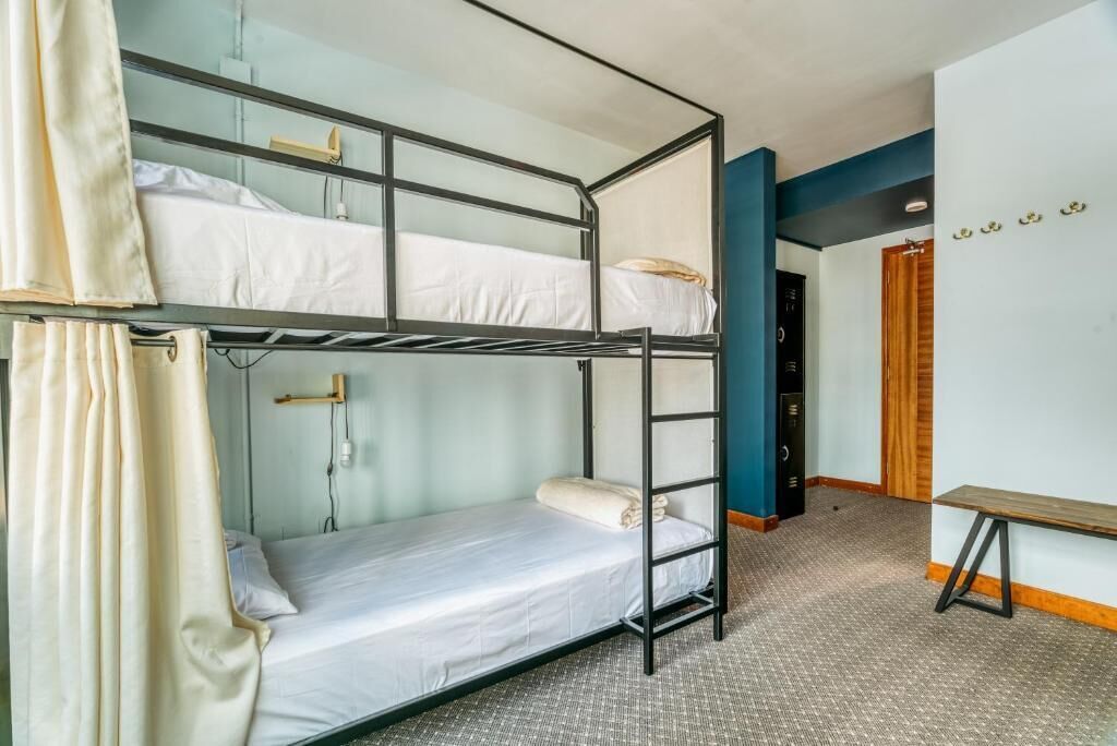 A bunk bed room with a desk and a door in the background.