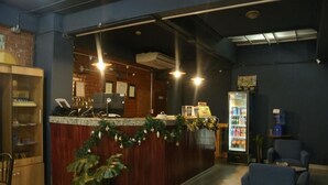 Un espace d’accueil comprenant un comptoir, un réfrigérateur et des sièges.