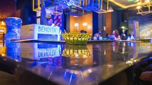 Un coin bar avec une bouteille d’eau, une pancarte sur laquelle on peut lire « BENDITA », et un panier tressé.