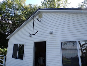 A white house with a garage door open, a window, and a chimney.