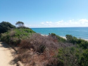 A coastal path leading to a beach with clear skies and ocean views. - La Ferme du Maquis (Antisanti)