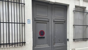 A double door with a red and blue sign, a window with a metal grill, and a small vent on the wall. - L'Echappée Urbaine Rouennaise - Hyper downtown - Rouen Left Bank Station (Rouen)