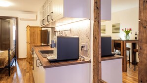 Une cuisine moderne avec des meubles en bois, une cuisinière encastrée et un coin repas comprenant une table et des chaises en bois.