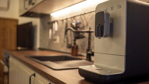 Une cuisine équipée d’une machine à café, d’un évier et de placards.