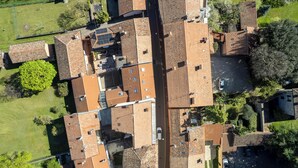 Vue aérienne d’un quartier résidentiel avec de nombreuses maisons, une rue principale et de la végétation environnante.