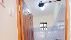 A bathroom with a toilet, a mirror, and a shower area.
