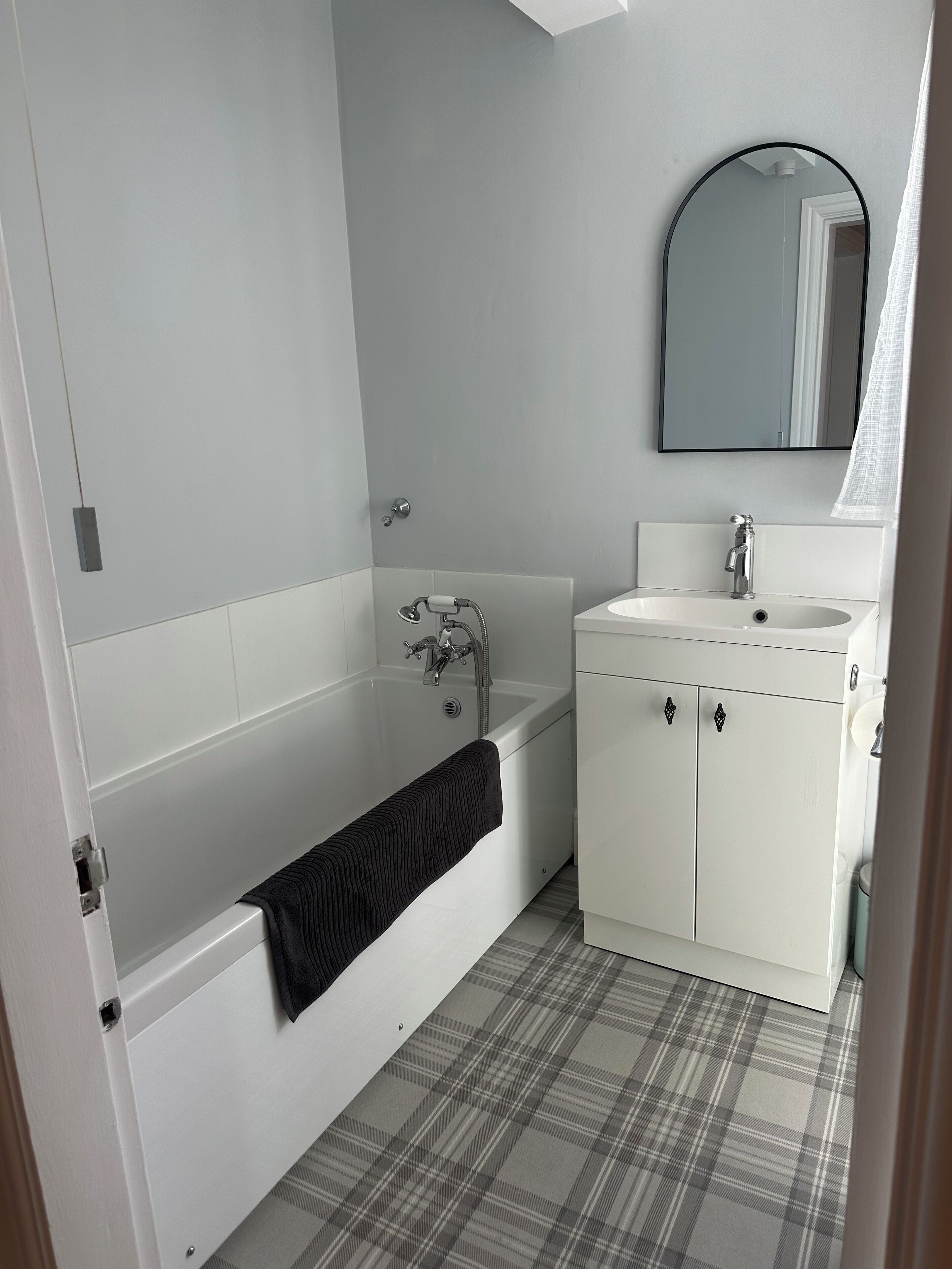 Un baño con bañera, lavabo y espejo.