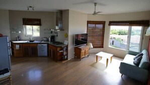 Amplia sala de estar con cocina, mesa de comedor y sofá.
