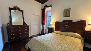 Una camera da letto con un letto, una cassettiera e una finestra con tende.
