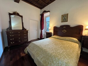 A bedroom with a bed, dresser, and a window with curtains. - AMAZING TRASTEVERE (Roma)